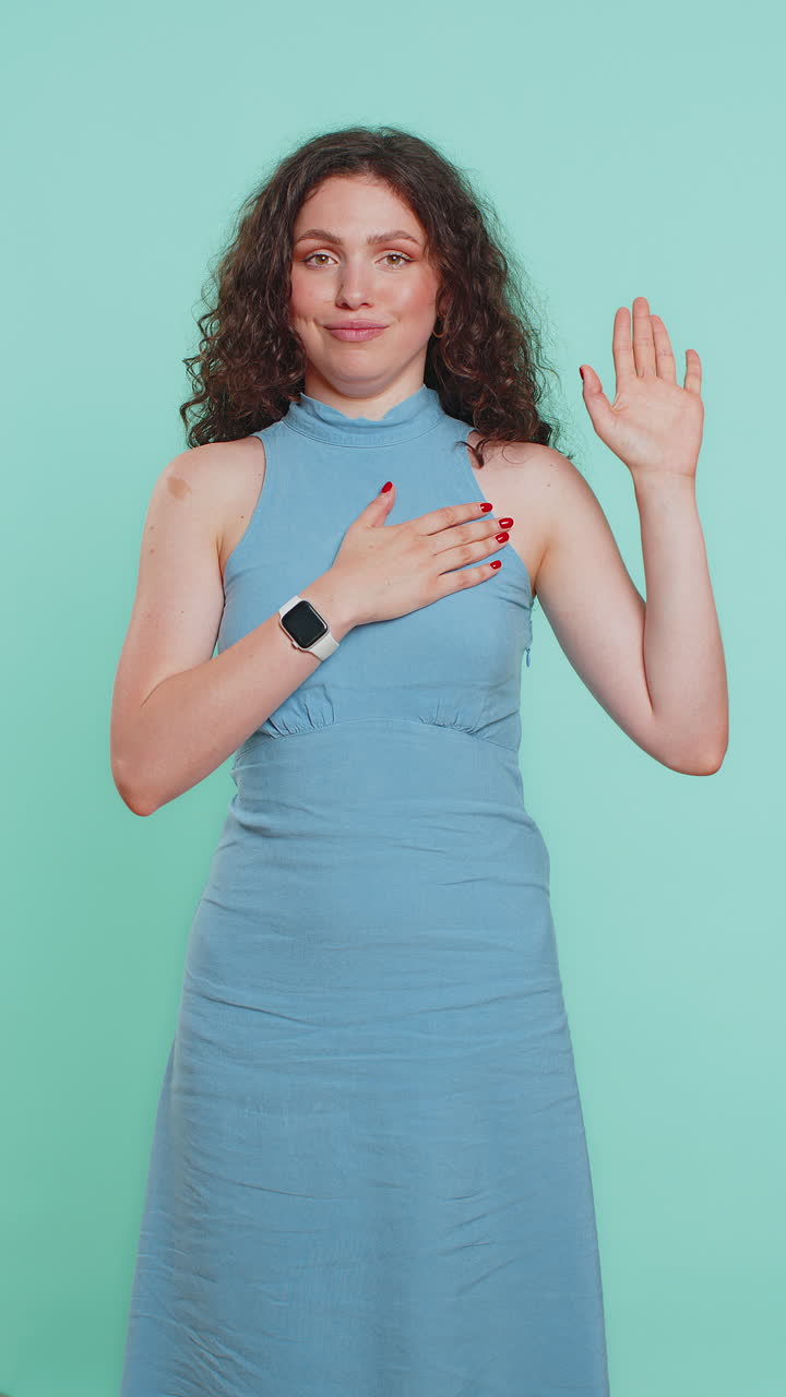 mujer levantando la mano para tomar el juramento prometiendo ser honesta y decir la verdad manteniendo la mano en el pecho