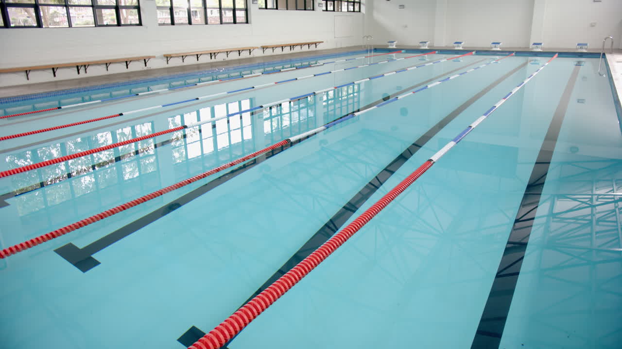Empty indoor swimming pool with lane dividers, ready for competitive swimmers, copy space