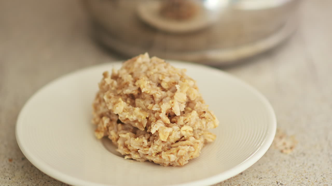 Plate of freshly cooked oatmeal being served with a spoon