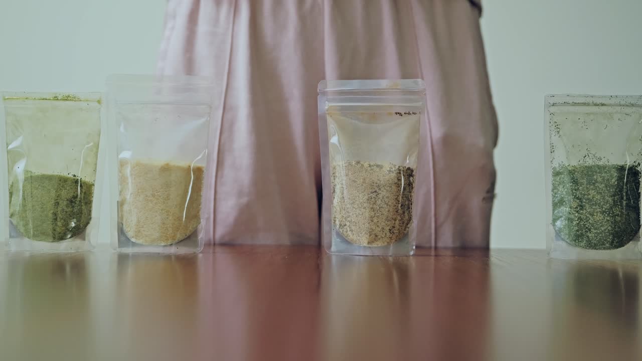 Slow motion shot of woman choosing natural spices for healthy homemade cooking