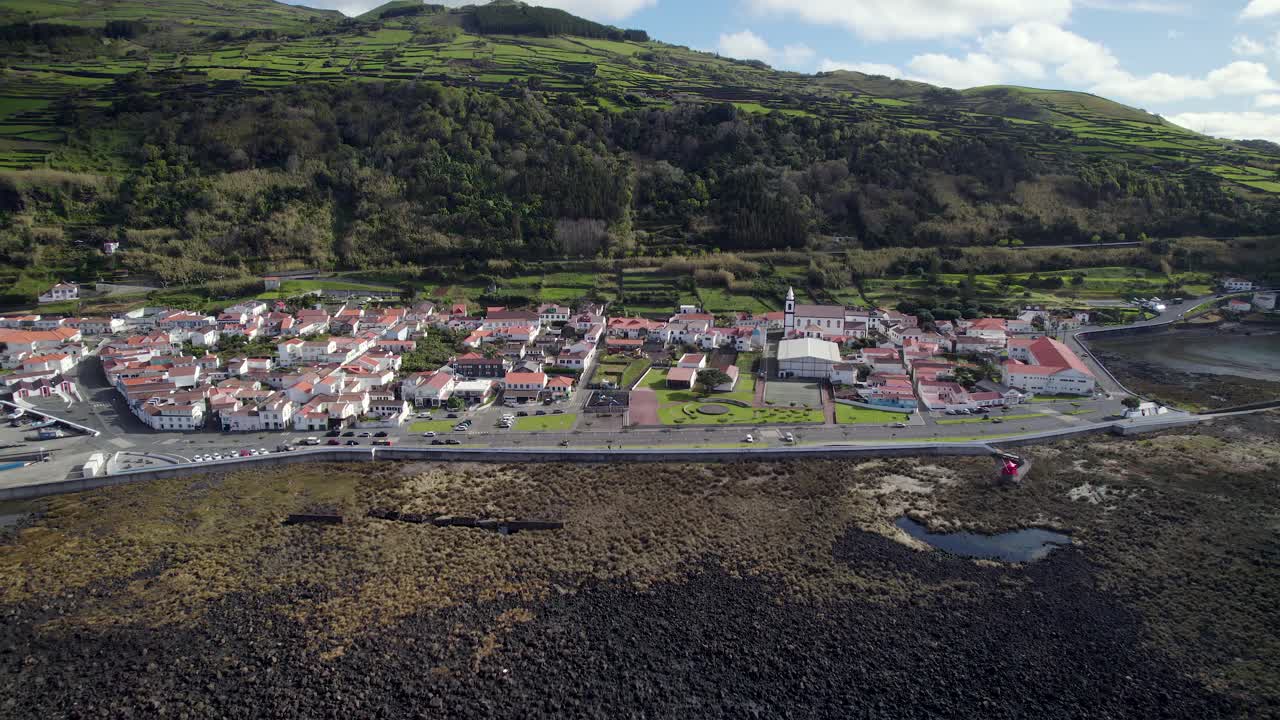 vista de retiro del avión no tripulado de la aldea costera de lajes do pico en la escarpada costa, azores