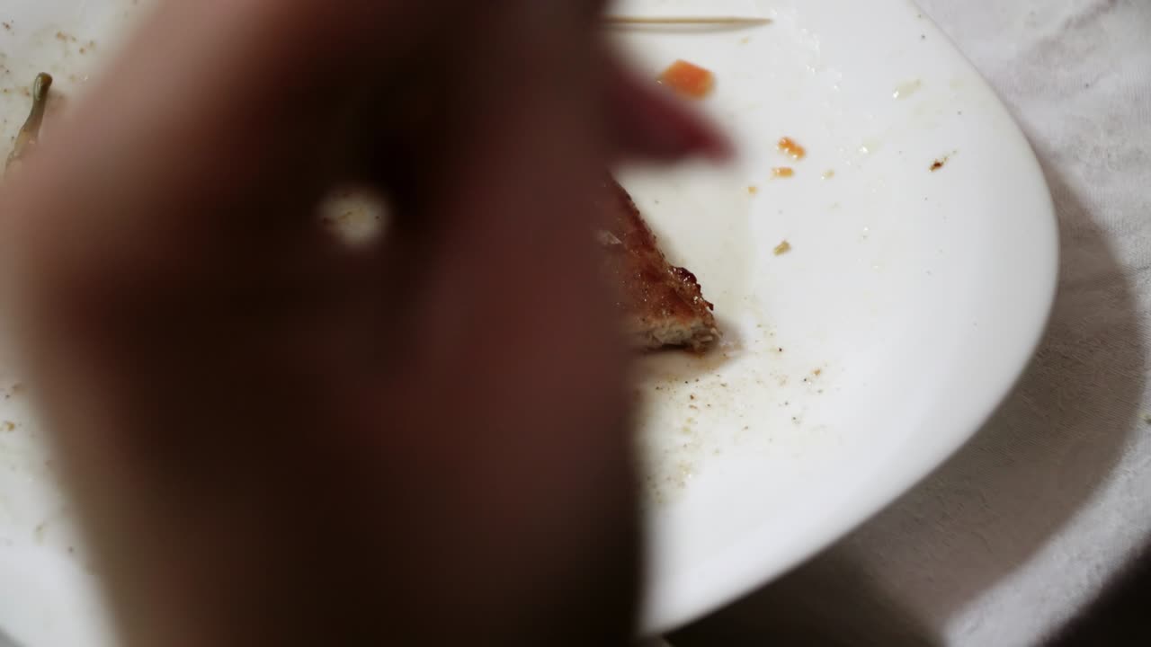 primer plano de manos humanas cortadas en pedazos pequeños de bistec de carne frita con tenedor y cuchillo