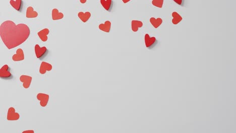corazones de papel rojo sobre fondo rosa en el día de san valentín
