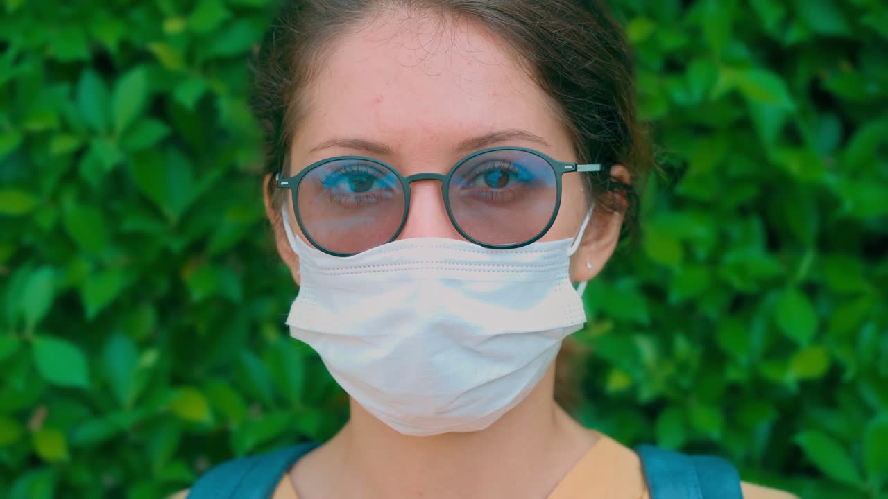 Giovane donna con mascherina e occhiali all'aperto