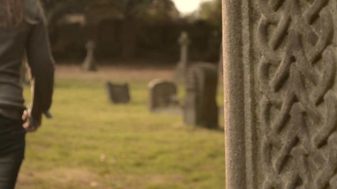 Una donna cammina attraverso un cimitero