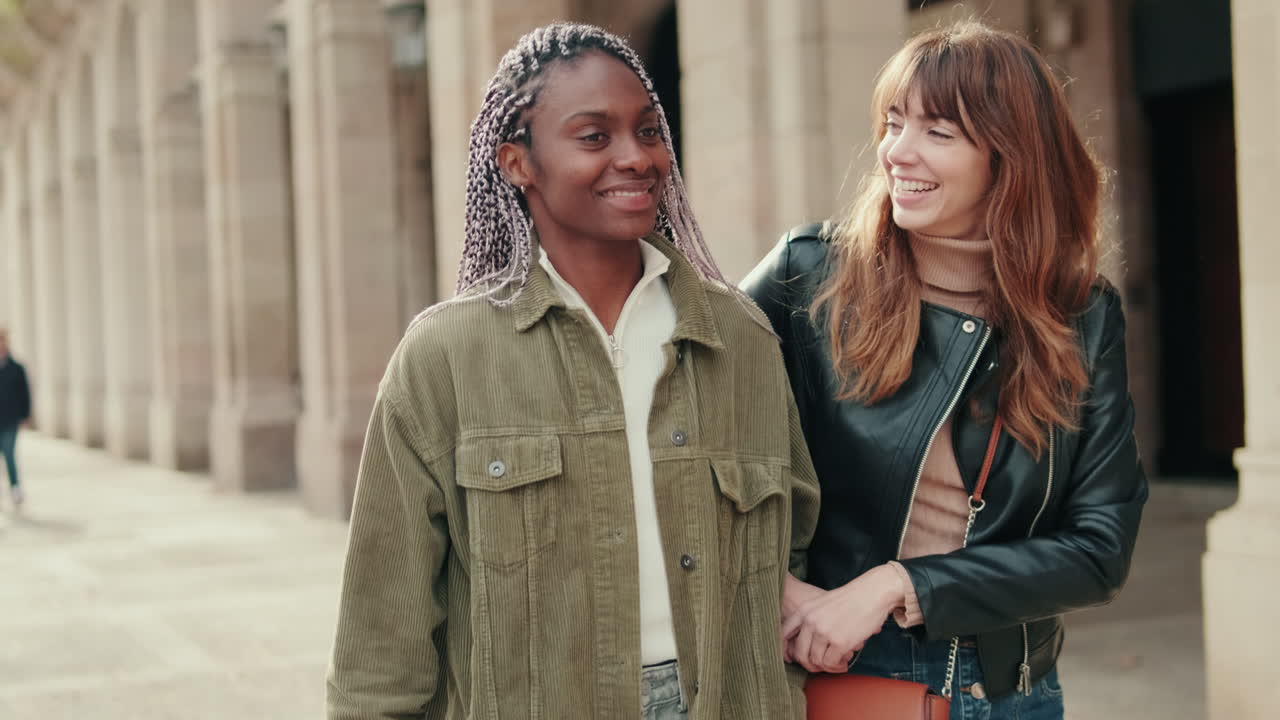 Duas Amigas Jovens Sorrindo e Conversando Enquanto Caminham