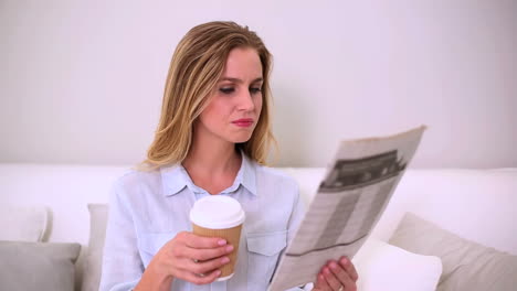 mujer leyendo el periódico y bebiendo café