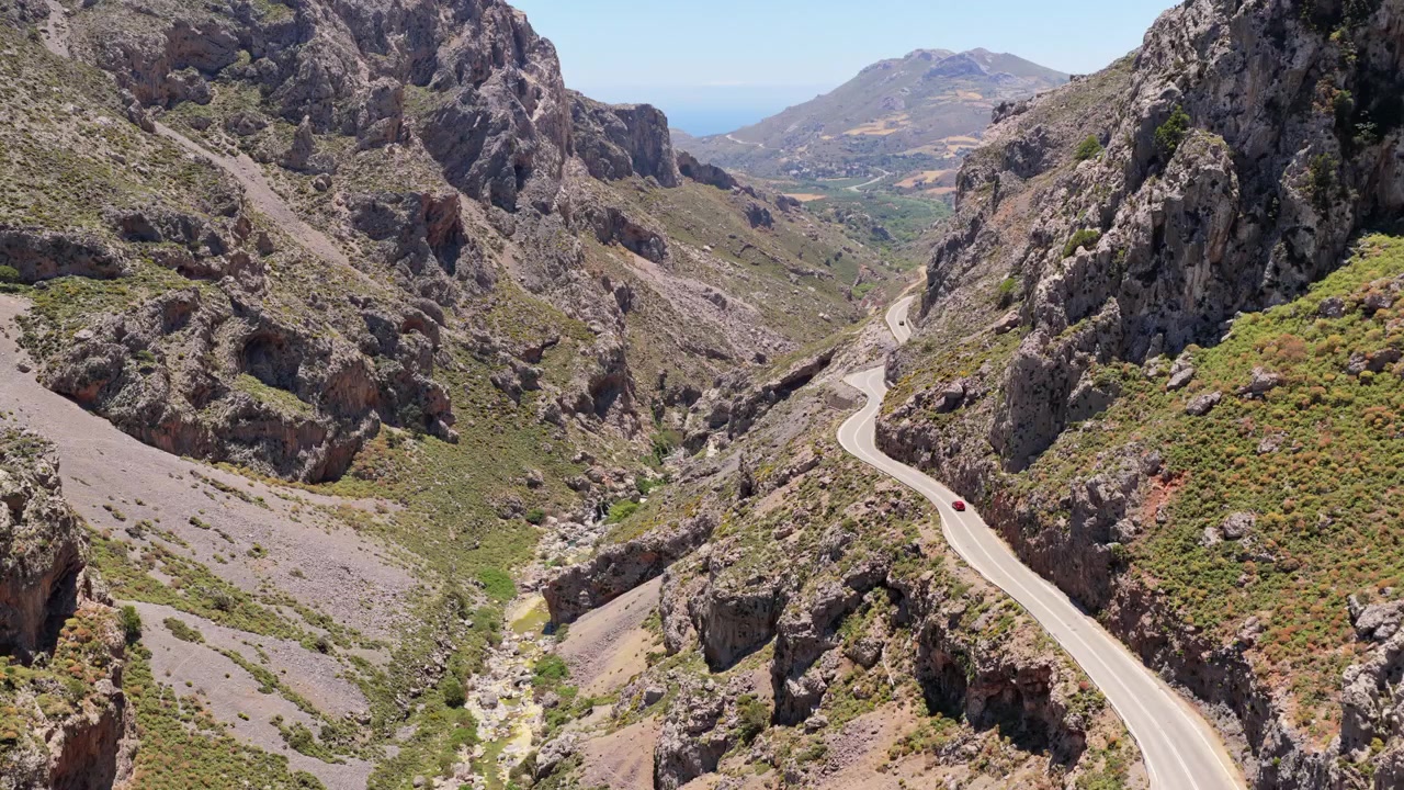 Vista aerea con drone di pozze fluviali turchesi tra massi con persone che nuotano in una gola rocciosa, Gola di Kourtaliotiko, Grecia