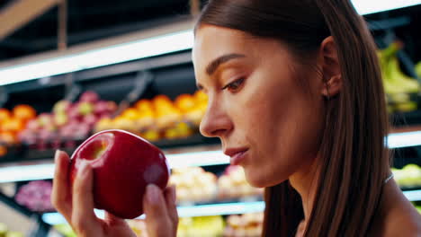 mujer comprando manzanas en una tienda de comestibles