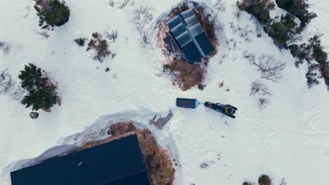 Vista-Aérea-De-La-Cabina-Y-La-Moto-De-Nieve-En-La-Montaña-Nevada-En-Invierno