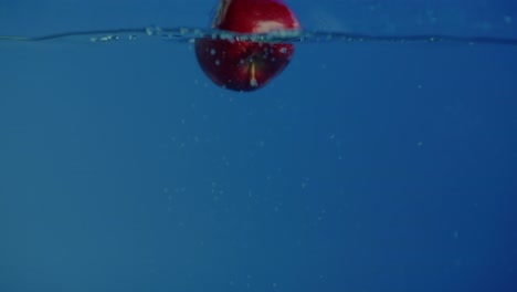 una deliciosa manzana roja cayó en un tanque lleno de agua