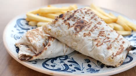 plate of shawarma wrap with fries