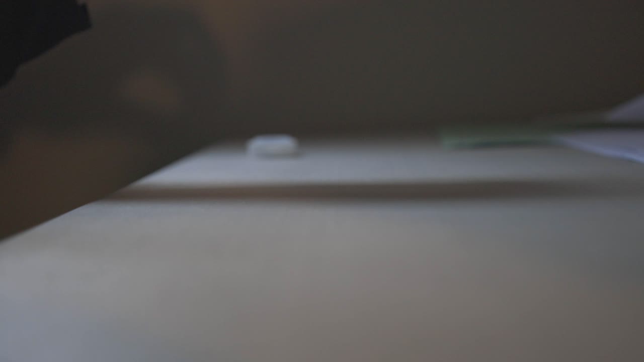 A Person Dropping Pills On The Table Inside A Room - Slow Motion