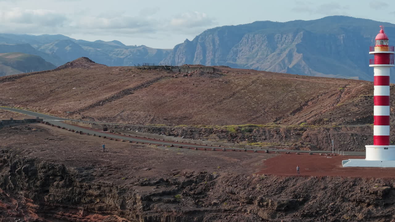 Woman walking on a path near the Punta Sardina lighthouse in Gran Canaria, Canary Islands, Spain