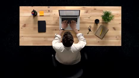 young man comes and works on laptop in daytime, work concept, office concept, communication concept, top shot