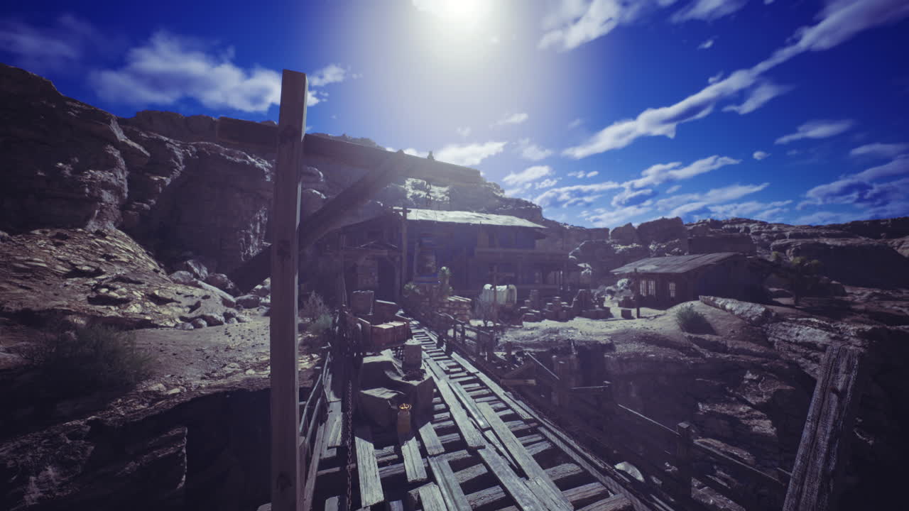 Old mining town under bright sky with wooden structures and rocky terrain