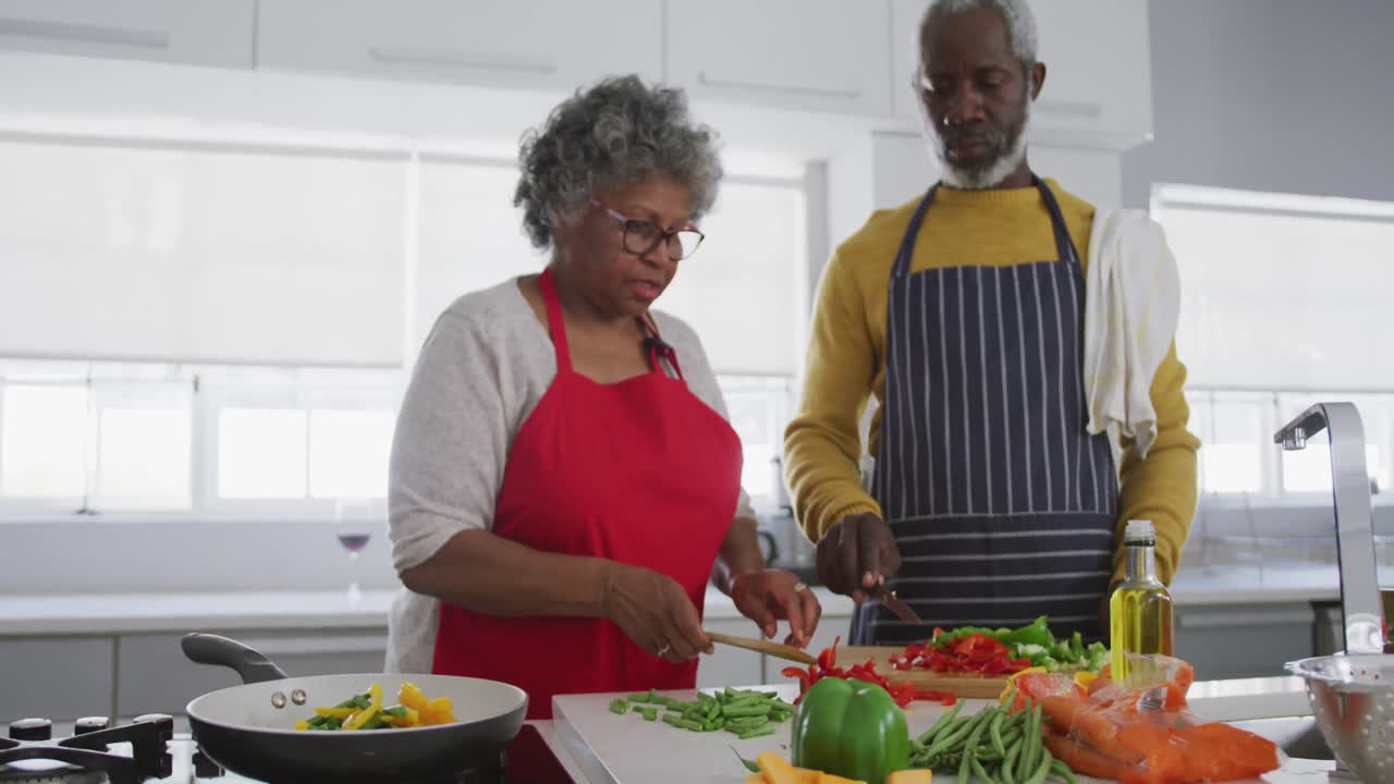 A senior African american couple cooking at home. Social distancing in quarantine