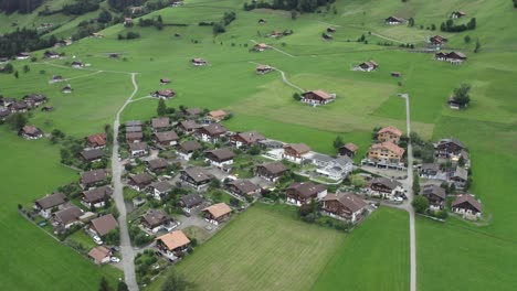 Die-Drohnenkamera-Schwenkt-Nach-Oben,-Wo-Viele-Bungalows-Von-Offenen-Gärten-Umgeben-Sind