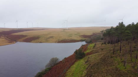 Schnelle-Schwenkende-Luftdrohne,-Die-über-Stausee-Mit-Windturbinen-Auf-Moorlandhügelhintergrund-4k-Geschossen-Wird