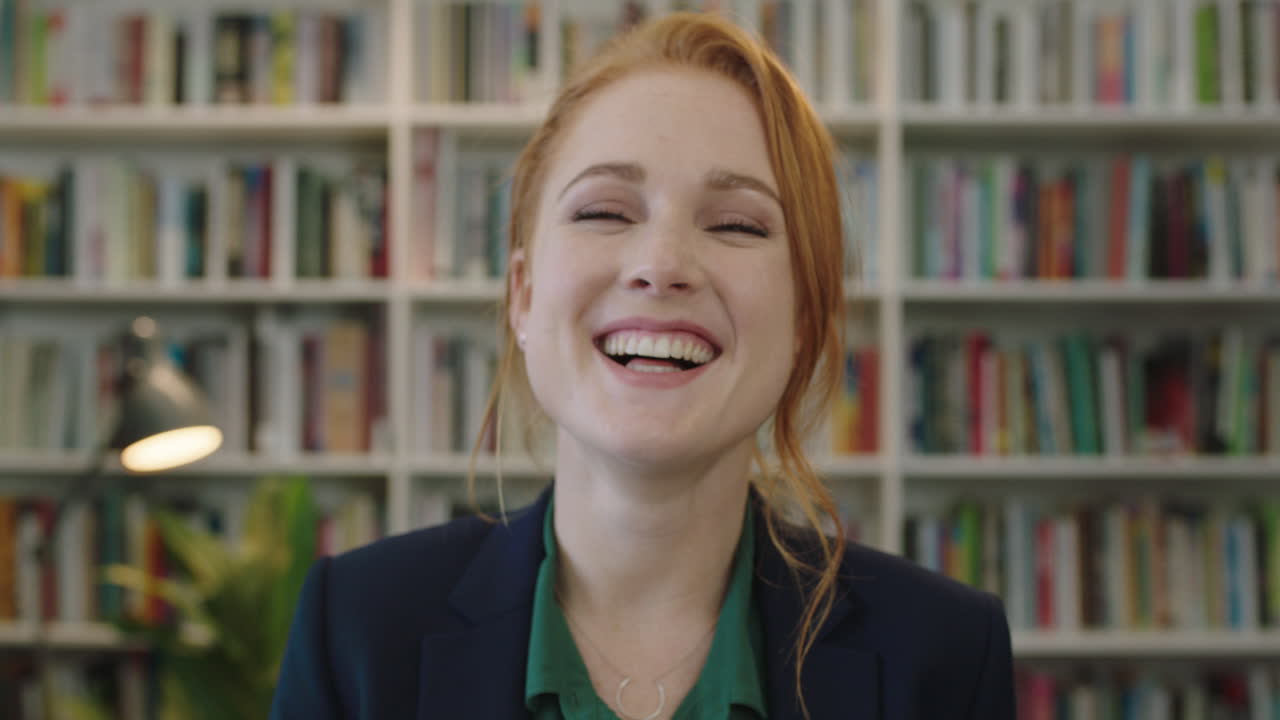 ritratto di una bella giovane donna d'affari con la testa rossa che ride allegra godendo di un'opportunità di carriera professionale in biblioteca