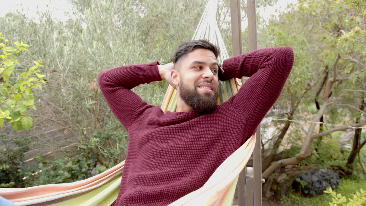 Relaxing in hammock, man enjoying leisure time outdoors in backyard