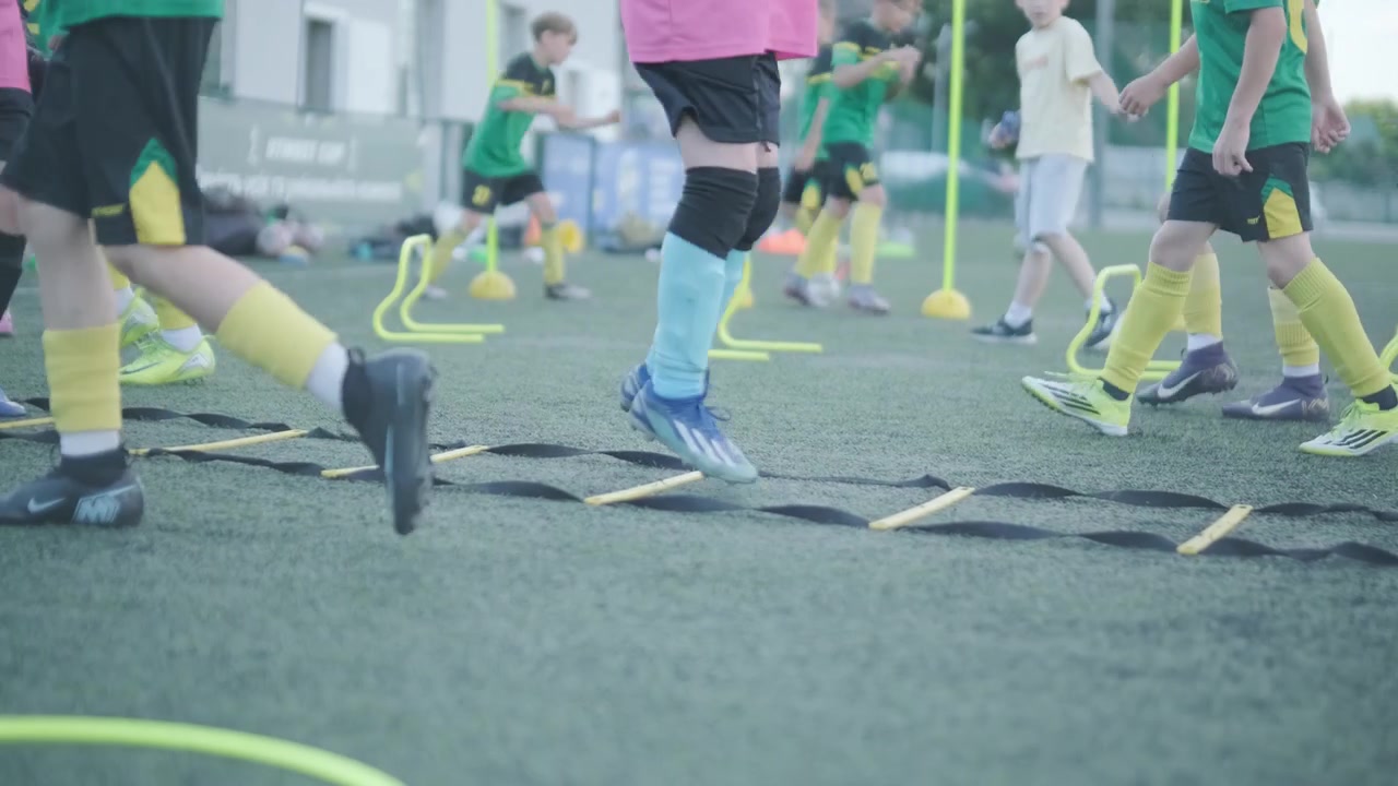 Jovens Jogadores de Futebol Praticando Exercícios de Agilidade em Gramado Sintético