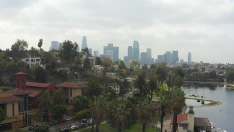 AERIAL:-Echo-Park-towards-Downtown-Los-Angeles,-California-with-Palm-Trees,-Cloudy