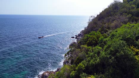 longtail boat crystal clear water on rocky sandy thai island beach