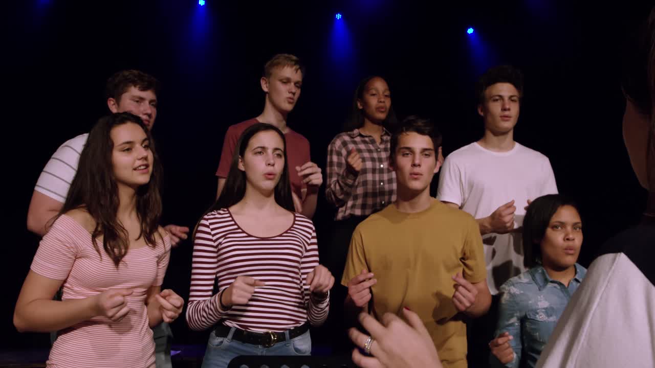 adolescentes ensayando en un teatro