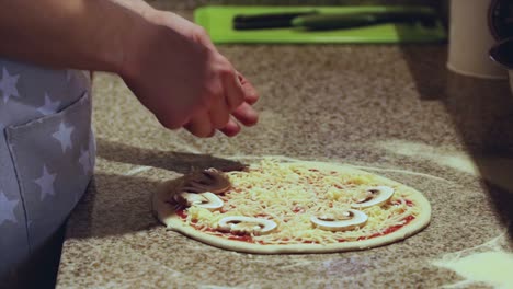 close-up of adding mushroom to a pizza