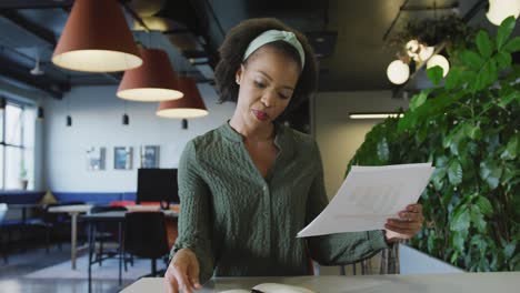 Portrait-of-african-american-businesswoman-talking-and-looking-at-camera-at-office