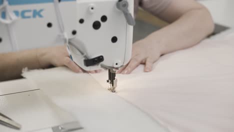 mujer que opera una máquina de coser en tela