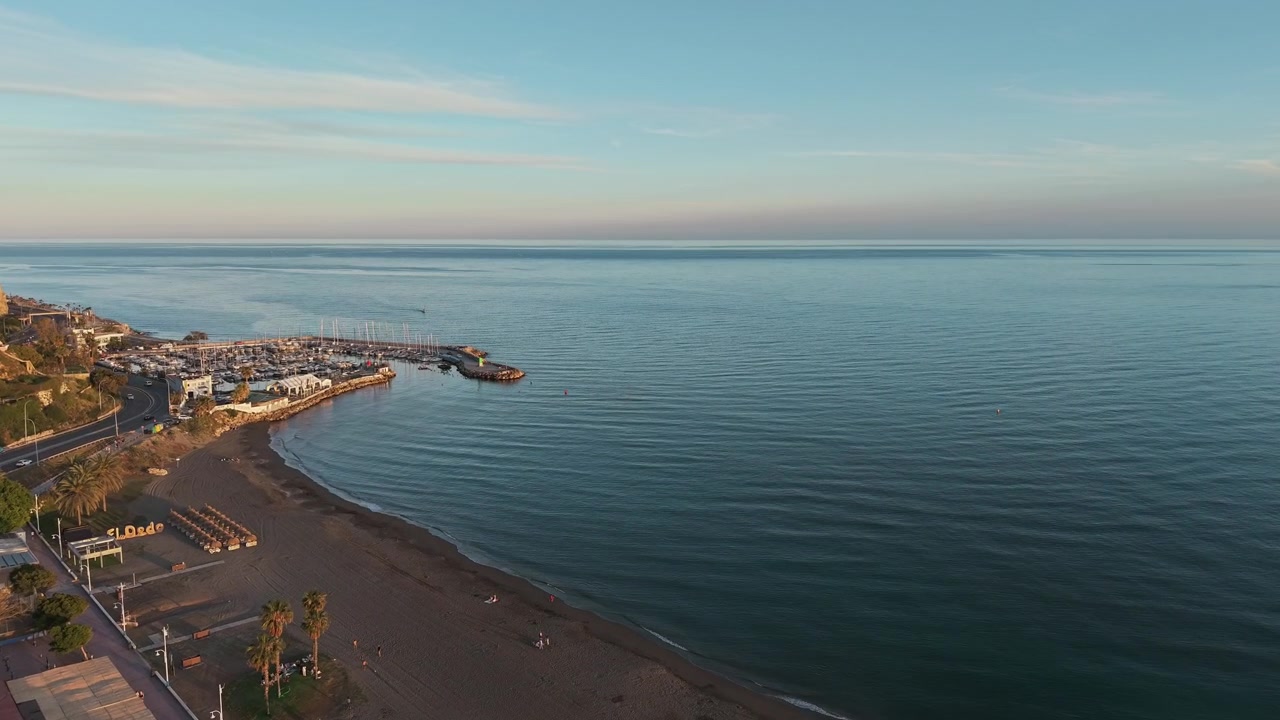 Malowniczy widok z lotu ptaka o zachodzie słońca na nadmorską dzielnicę mieszkalną Malagi z plażą El Dedo, Andaluzja, Hiszpania