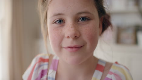 portrait beautiful happy girl with cute freckles smiling child looking at camera enjoying childhood happiness wearing colorful dress at home 4k