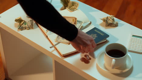 a caucasian woman puts her american passport on the coffee table