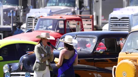 dos mujeres hablando cerca de coches estacionados