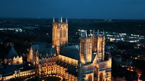 aerial drone video captures the renowned lincoln cathedral in lincolnshire, uk, at dusk, showcasing its majestic gothic architecture with illumination