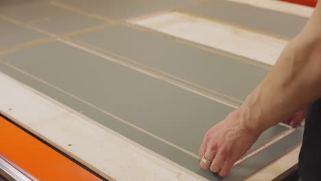 employee takes away wooden board detail in woodwork shop