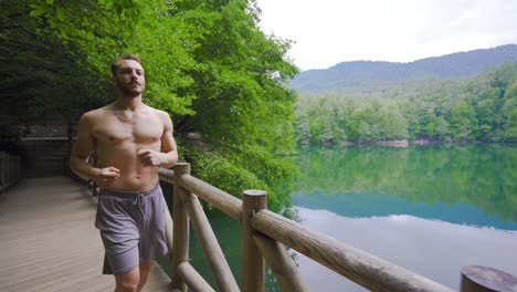 muscular male running in the forest.