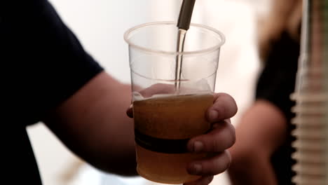 Bartender-pouring-beer-for-customer-at-music-festival-in-Central-London