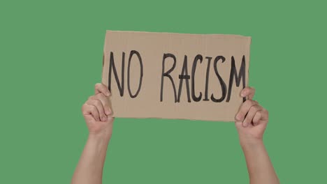 female hands hold a poster from a cardboard box with the words no racism. protest against racism and police brutality. isolated a green screen, chroma key. close up. slow motion