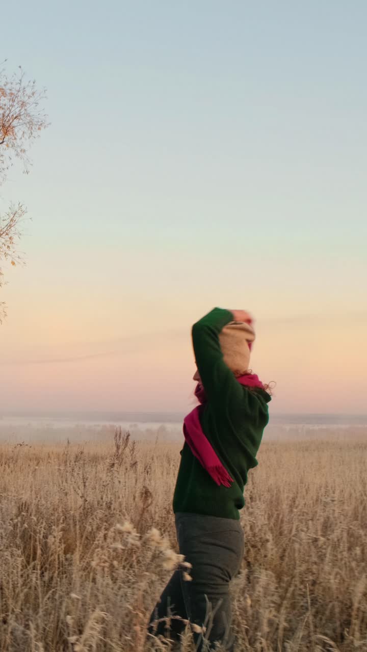 Woman enjoying a sunrise in a field