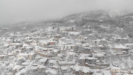 aerial footage over snowy mountain, traditional village in greece 8