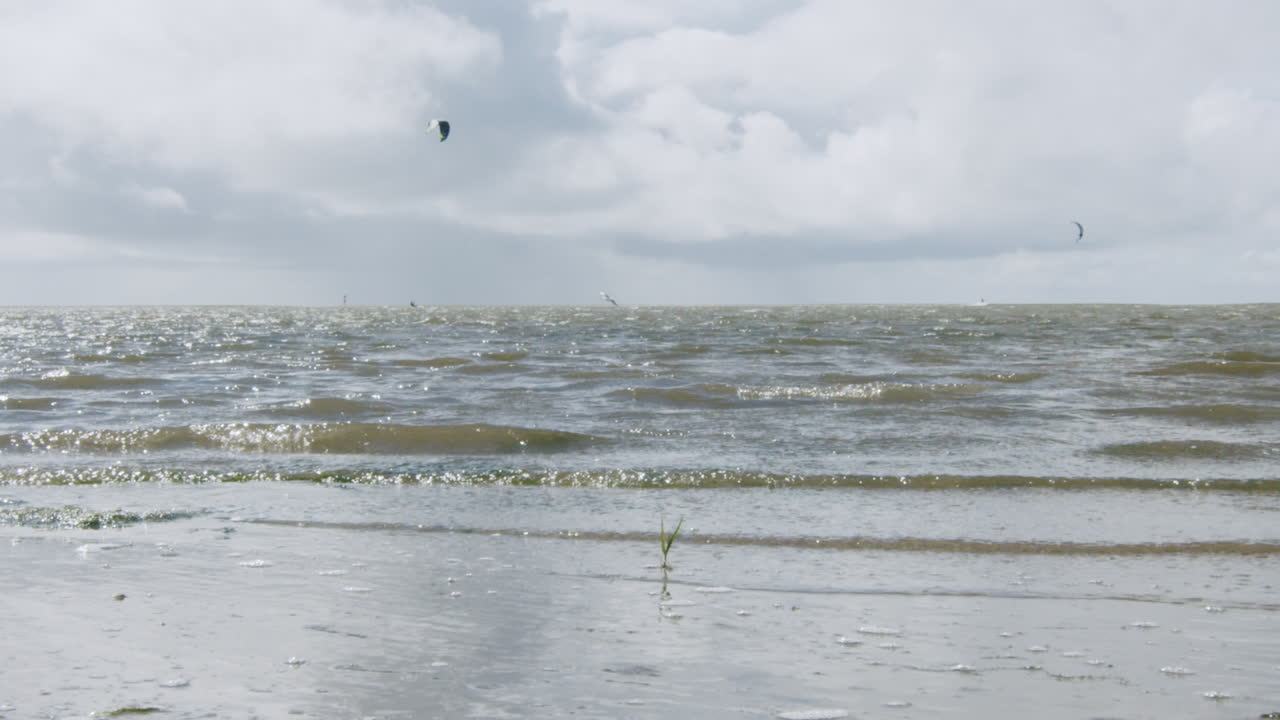 disparo en cámara lenta de pequeñas olas que golpean la orilla en la playa de st. peter ording