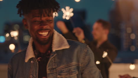 cheerful-group-of-friends-holding-sparklers-celebrating-new-years-eve-on-rooftop-at-night-having-fun-dancing-enjoying-holiday-party-celebration-diverse-young-people-waving-festive-fireworks