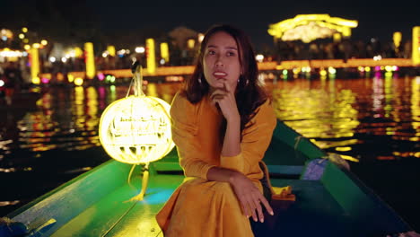 매력적인 베트남 여성은 밤에 강 배에서 빛의 반사를보고, hoi an, 베트남