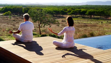 couple doing yoga on wooden plank 4k