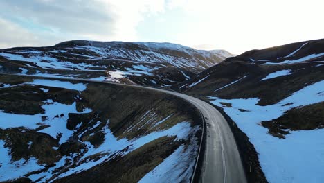 Drohnenansicht-Einer-Verlassenen-Isländischen-Straße-In-Verschneiter-Berglandschaft