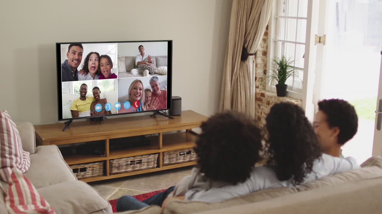 아프리카계 미국인 가족 이 집 에서 소파 에 앉아 tv 에서 비디오 통화 를 하고 있다