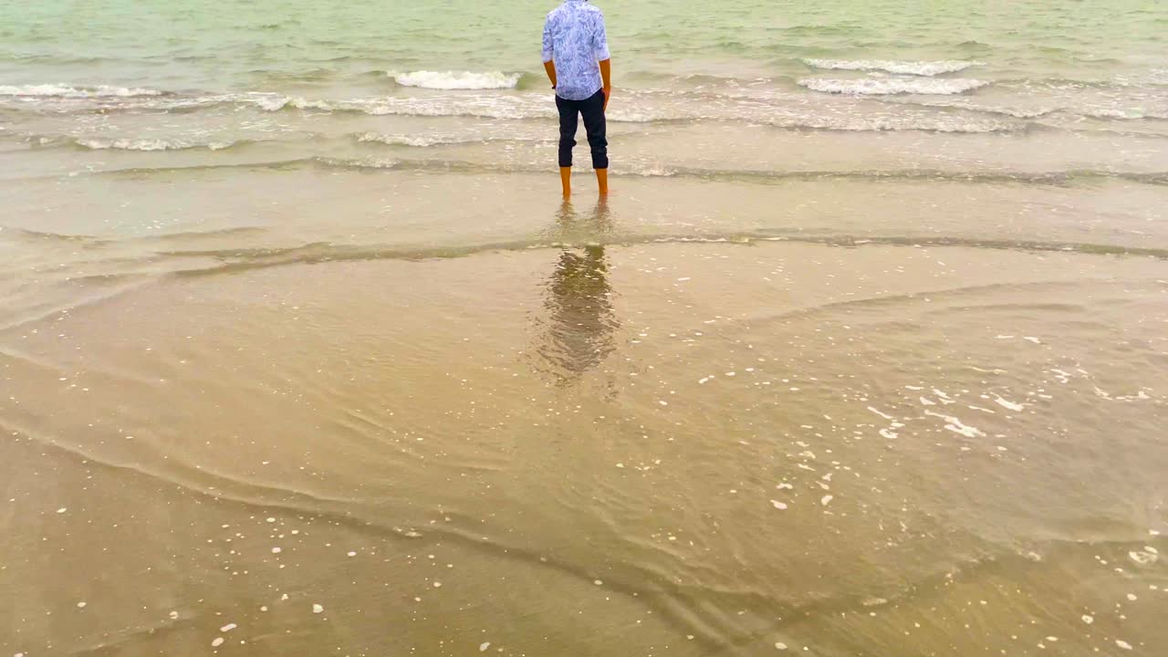 A Man Standing Alone On The Shores Of Kuakata Beach In Bangladesh. Tilt-up Shot